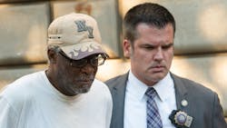 Gregory Fleetwood (left) is escorted from the Bronx Detective Bureau headquarters by Detective Robert Klein on Monday after being charged in the 1996 homicide of Jasmine Porter.