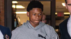 Oshawn Logan, 18, is escorted from the NYPD's 43rd Precinct stationhouse in the Bronx on Friday. He's accused of taking part in the violent mugging of an off-duty NYPD officer.