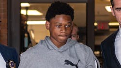 Oshawn Logan, 18, is escorted from the NYPD&apos;s 43rd Precinct stationhouse in the Bronx on Friday. He&apos;s accused of taking part in the violent mugging of an off-duty NYPD officer.