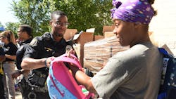 St. Paul, MN, Police Officer Lorenzo Lamb hands a backpack to Demetria Smith at the second annual Barbers & Backpacks event Tuesday at St. Paul's Conway Recreation Center. The event is sponsored by the Minnesota Chapter of the National Black Police Association. St. Paul, MN, Police Officer Lorenzo Lamb hands a backpack to Demetria Smith at the second annual Barbers & Backpacks event Tuesday at St. Paul's Conway Recreation Center. The event is sponsored by the Minnesota Chapter of the National Black Police Association.