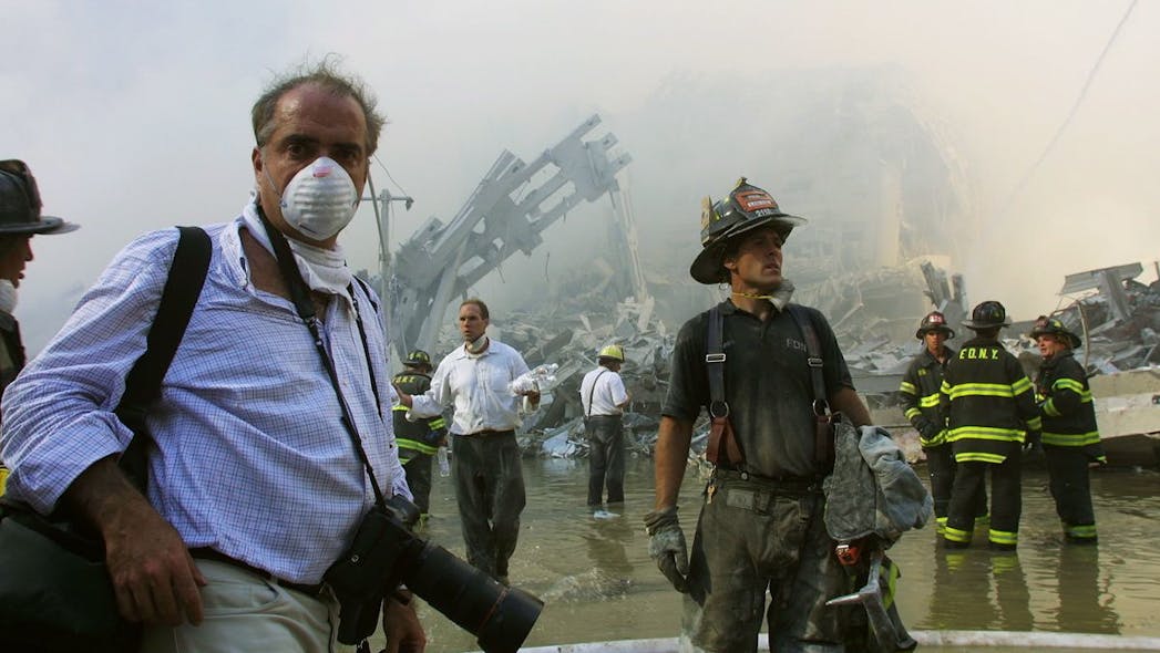 FDNY firefighters and a photojournalist work at the World Trade Center after two hijacked planes crashed into the Twin Towers on Sept. 11, 2001, in New York City.
