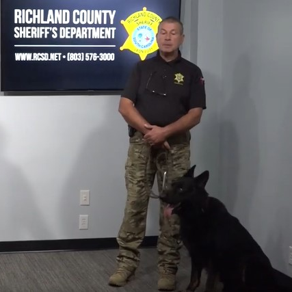 Hammer, a Richland County, SC, Sheriff's Department K-9, and his trainer and handler, Michel Galliot, attend a press conference Monday announcing the addition of new dogs to the agency.