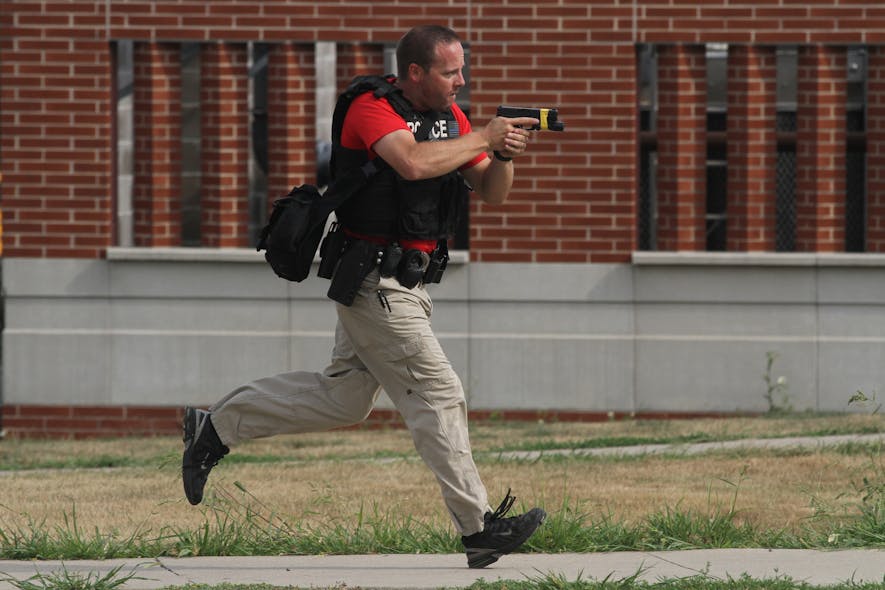An officer carries a drawn handgun during an active shooter training session in Indianola, Iowa.
