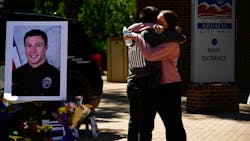 Arvada, CO, Police Officer Joe Galvez gets a hug from a friend outside of the Arvada Police Department, where a memorial has been set up for Officer Dillon Vakoff, who was killed Sunday. Arvada, CO, Police Officer Joe Galvez gets a hug from a friend outside of the Arvada Police Department, where a memorial has been set up for Officer Dillon Vakoff, who was killed Sunday.