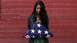 Folds of Honor scholarship recipient, Tayler Garber, holding a folded American flag. Folds of Honor scholarship recipient, Tayler Garber, holding a folded American flag.