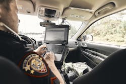 An officer with the Melbourne Police Department is seen inside his patrol car working on a TOUGHBOOK laptop.