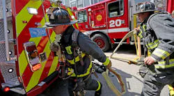 Boston firefighters haul hose into the scene of a multi-alarm fire in the Dorchester area in July.