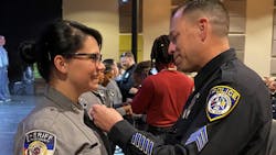 Escondido, CA, Police Sgt. Jeff Valdivia pins the badge on El Paso County, CO, Sheriff's Deputy Natalie Young at her graduation earlier this month. Valdivia had rescued her from her drug-addicted mother 22 years earlier. Escondido, CA, Police Sgt. Jeff Valdivia pins the badge on El Paso County, CO, Sheriff's Deputy Natalie Young at her graduation earlier this month. Valdivia had rescued her from her drug-addicted mother 22 years earlier.