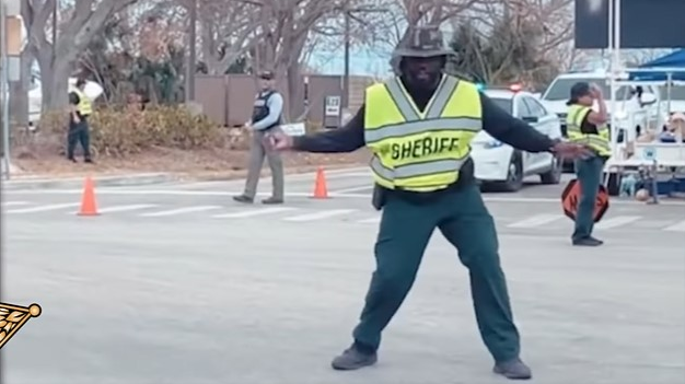 Lee County, FL, Sheriff's Deputy Carl Elie dances as he directs traffic in Fort Myers Beach, which was hit hard by Hurricane Ian.