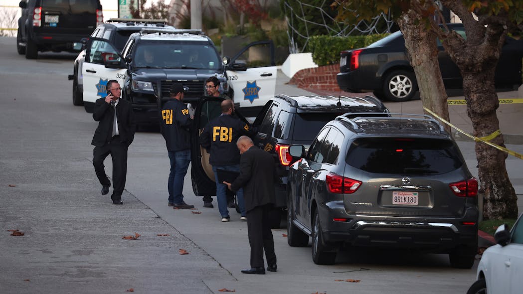 San Francisco police officers and FBI agents gather in front of the home of U.S. Speaker of the House Nancy Pelosi on Friday after her husband was violently attacked by an intruder.