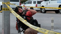 An ATF agent passes a St. Louis police SWAT vehicle at the scene of a shooting at Central Visual & Performing Arts High School and the Collegiate School of Medicine and Bioscience on Monday. An ATF agent passes a St. Louis police SWAT vehicle at the scene of a shooting at Central Visual & Performing Arts High School and the Collegiate School of Medicine and Bioscience on Monday.