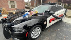 The police cruiser of London, KY, Police Officer Logan Medlock, 26, who was killed Sunday in a fatal crash, is draped in black cloth, ribbon, and covered with flowers outside of the department. The police cruiser of London, KY, Police Officer Logan Medlock, 26, who was killed Sunday in a fatal crash, is draped in black cloth, ribbon, and covered with flowers outside of the department.