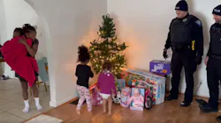 South Bend, IN, police officers watch as a family reacts to finding replacement gifts Christmas Eve after the home was robbed earlier, and the holiday presents stolen.