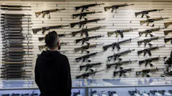 A customer looks at a selection of firearms, many of which fall under Illinois' new assault weapons ban, at R-Guns store on in Carpentersville.