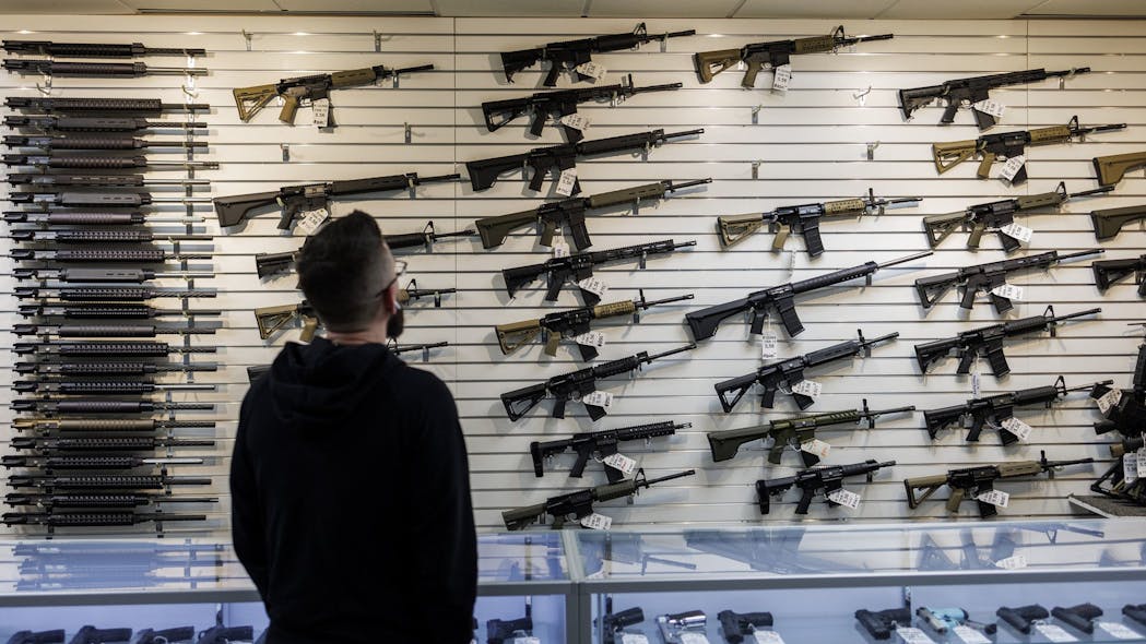 A customer looks at a selection of firearms, many of which fall under Illinois' new assault weapons ban, at R-Guns store on in Carpentersville. A customer looks at a selection of firearms, many of which fall under Illinois' new assault weapons ban, at R-Guns store on in Carpentersville.