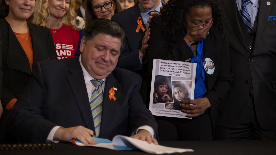 Illinois Gov. J.B. Pritzker signs comprehensive legislation to ban military-style firearms Tuesday at the Illinois Capitol in Springfield.