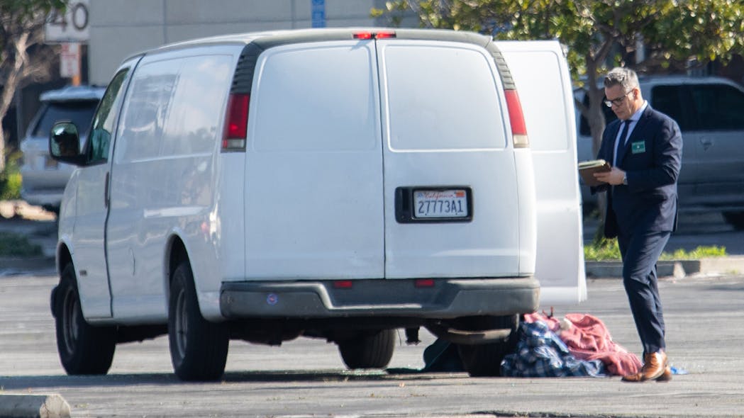 Investigators check out a van where the driver is suspected in a mass shooting at a Monterey Park, CA, dance studio Sunday that killed 10.