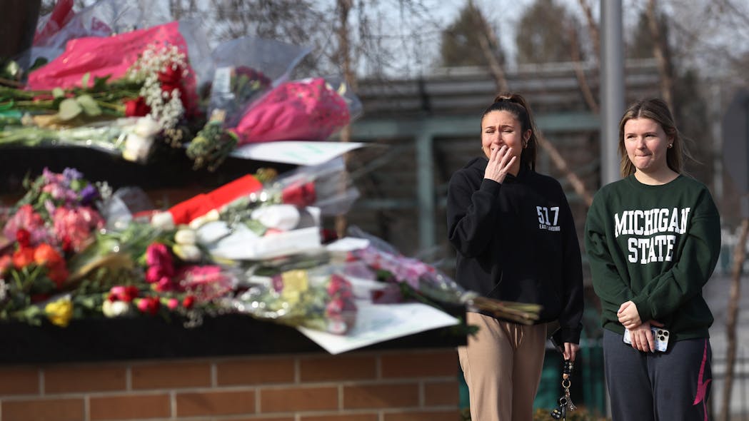 People visit the Spartan statue on the campus of Michigan State University in East Lansing on Tuesday after a gunman opened fire at two locations on the campus Monday night, killing three students and injuring several others.