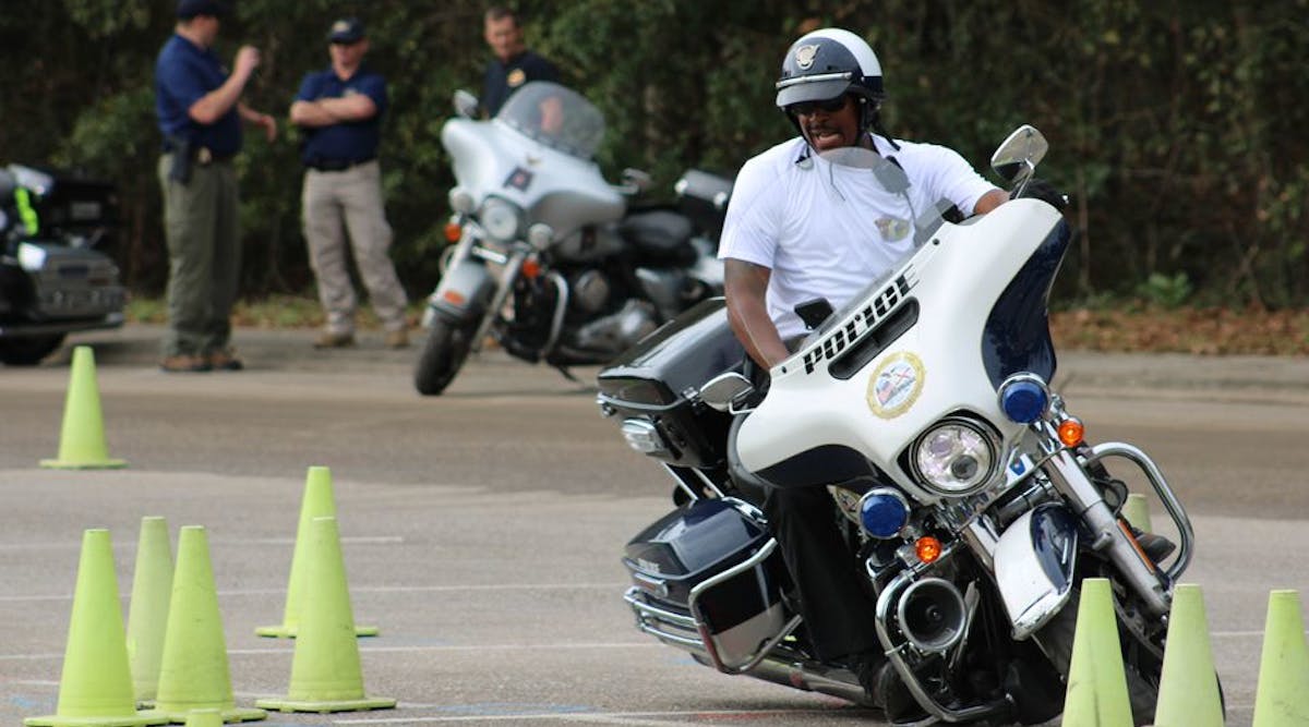 A Mobile, AL, police officer pushes his Harley-Davidson into the tightest turn possible Wednesday as he works his way through a training course set up to help officers prepare for Mardi Gras duty.