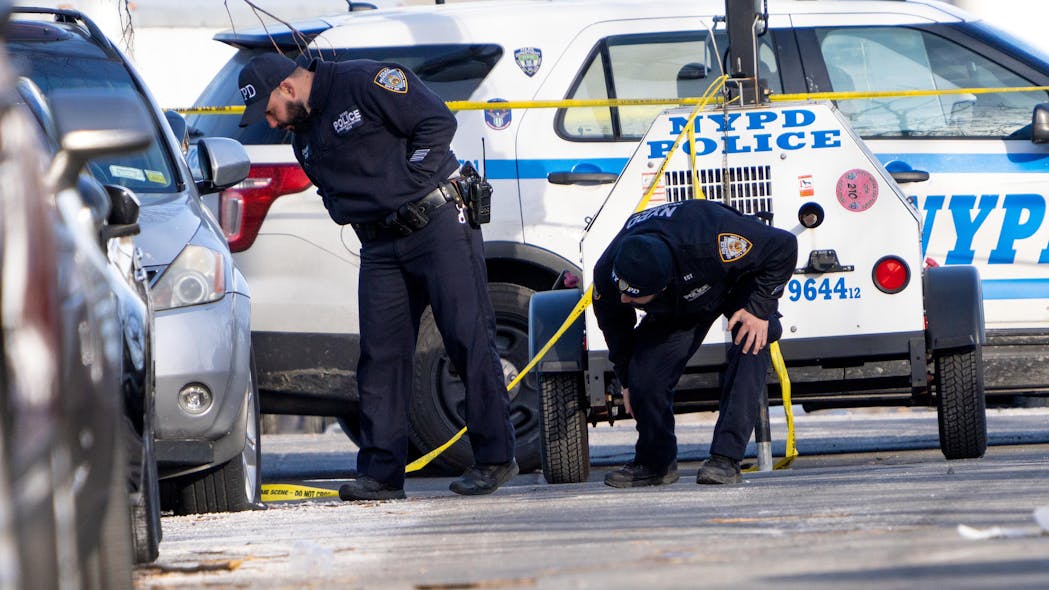 Investigators search for evidence in Brooklyn on Sunday at the scene where an off-duty NYPD officer was shot in the head during a phony car sale. Investigators search for evidence in Brooklyn on Sunday at the scene where an off-duty NYPD officer was shot in the head during a phony car sale.