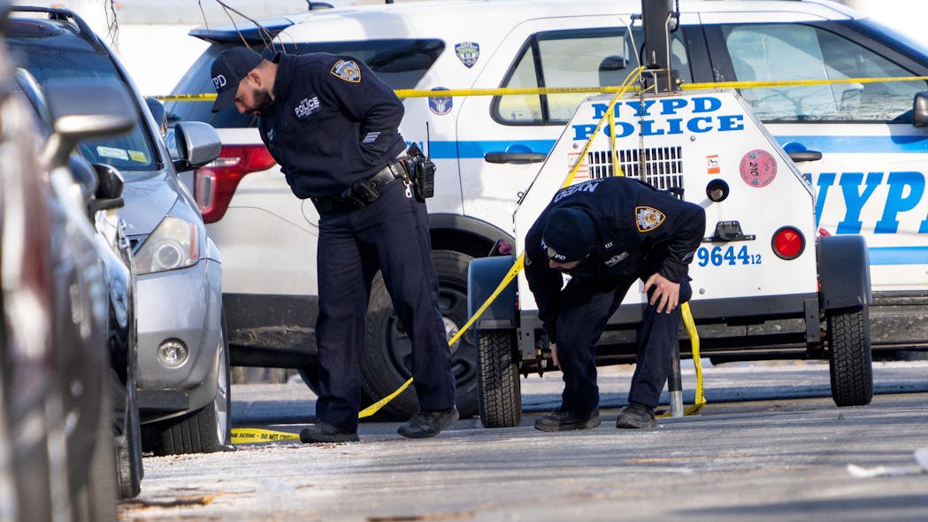Investigators search for evidence in Brooklyn on Sunday at the scene where an off-duty NYPD officer was shot in the head during a phony car sale.