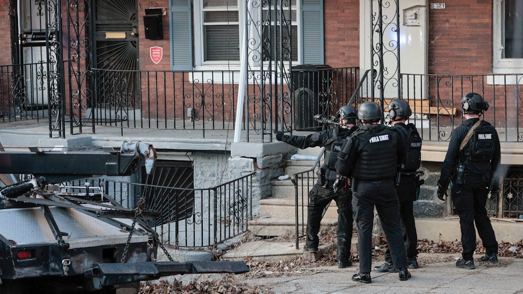 SWAT officers converge on the scene of a shooting where a Philadelphia police officer was shot twice during a vehicle investigation in West Philadelphia on Wednesday.