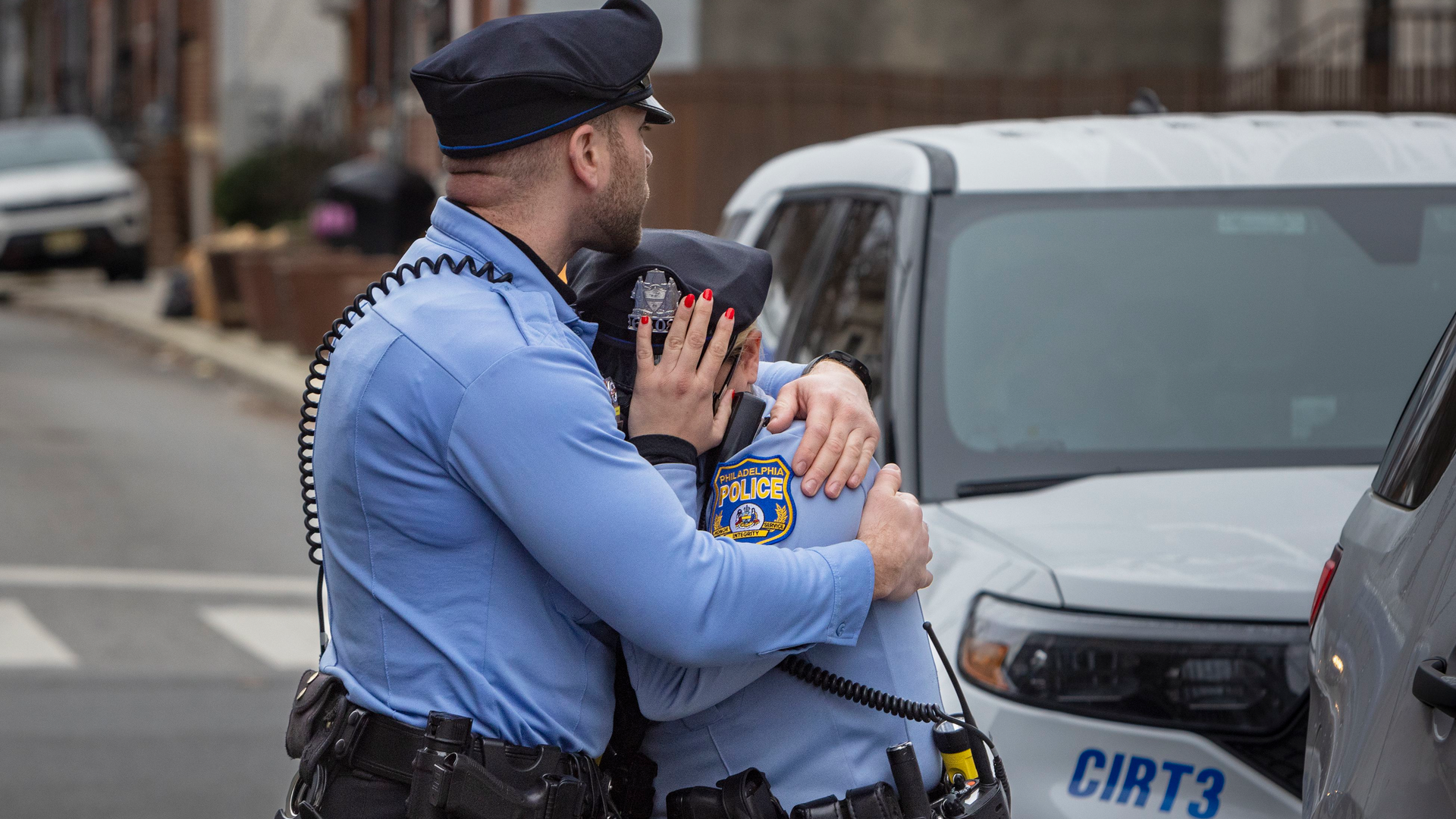 A Philadelphia police officer is consoled Monday after a visit to the memorial for Temple University Police Officer Christopher Fitzgerald, who was shot and killed in the line of duty Saturday.
