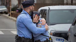 A Philadelphia police officer is consoled Monday after a visit to the memorial for Temple University Police Officer Christopher Fitzgerald, who was shot and killed in the line of duty Saturday.