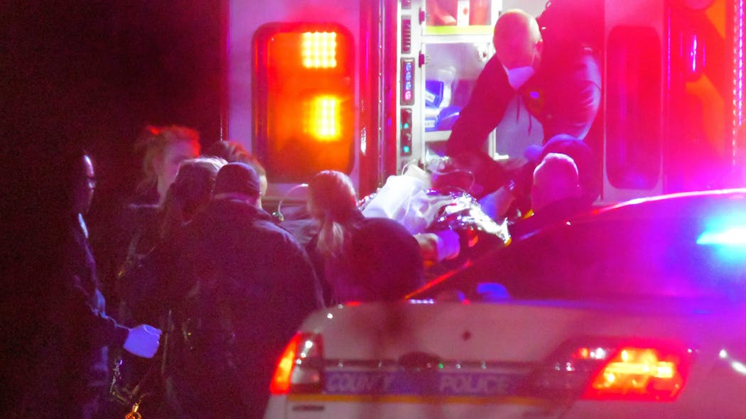 Police stand by as medical personnel transfer Baltimore County Police Detective Jonathan Chih from an ambulance to a Maryland State Police medevac at a landing zone outside Cockeysville Middle School on Thursday.