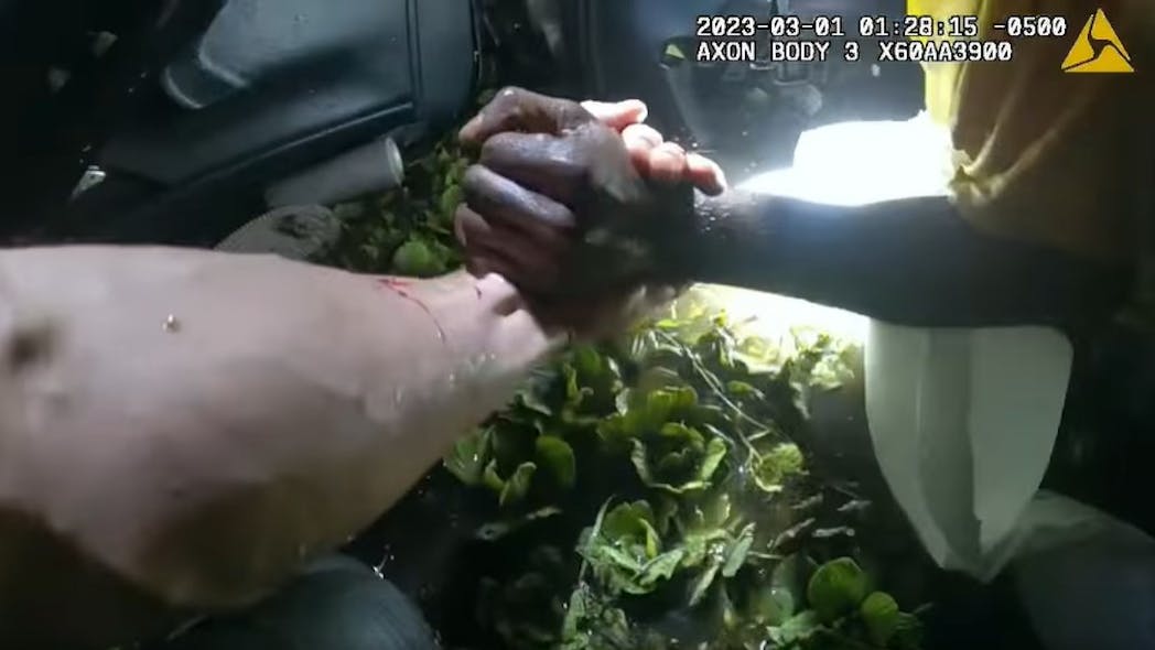 A Martin County, FL, sheriff's deputy pulls out a driver trapped in an overturned vehicle submerged in a canal Wednesday. A Martin County, FL, sheriff's deputy pulls out a driver trapped in an overturned vehicle submerged in a canal Wednesday.