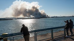 Bystanders watch as a massive fire engulfs an NYPD evidence warehouse in Brooklyn on Dec. 13.