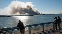 Bystanders watch as a massive fire engulfs an NYPD evidence warehouse in Brooklyn on Dec. 13.
