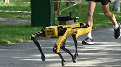 A man jogs past a four-legged robot called Spot at the Bishan-Ang Moh Kio Park in Singapore in 2020.