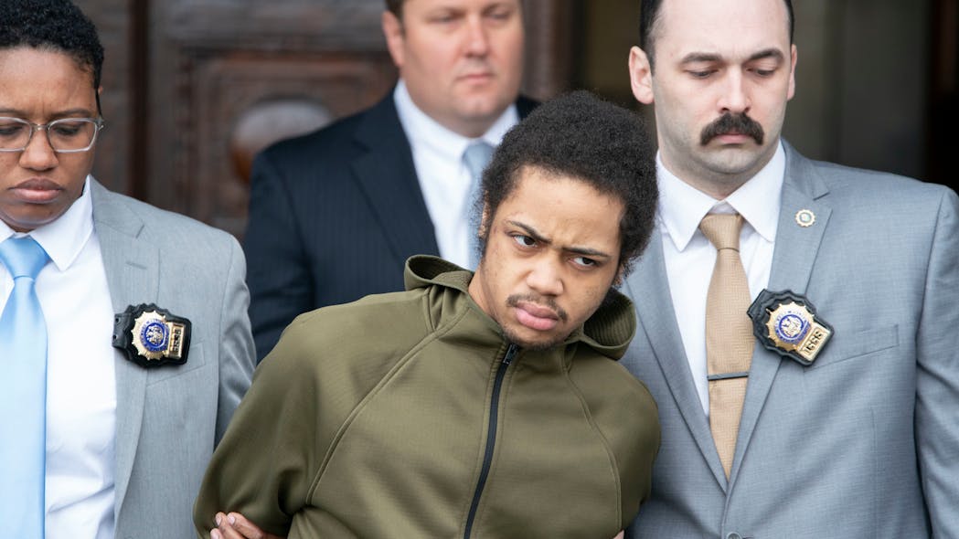 Devin Spraggins, 22, is seen in police custody outside the NYPD 103rd Precinct stationhouse Friday. Spraggins is accused of shooting of rookie NYPD Officer Brett Boller. Devin Spraggins, 22, is seen in police custody outside the NYPD 103rd Precinct stationhouse Friday. Spraggins is accused of shooting of rookie NYPD Officer Brett Boller.