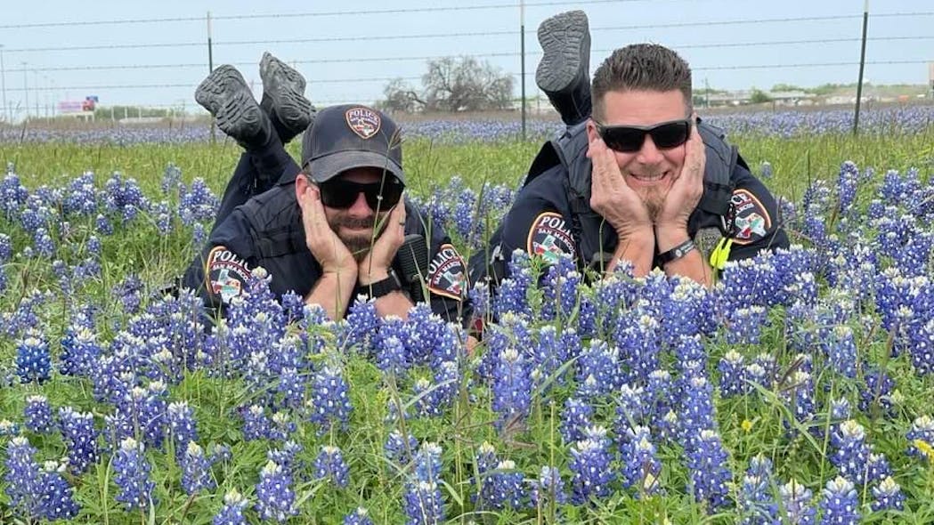Two San Marcos, CA, police officers pose in a field of bluebonnet flowers as part of a viral online challenge. Two San Marcos, CA, police officers pose in a field of bluebonnet flowers as part of a viral online challenge.