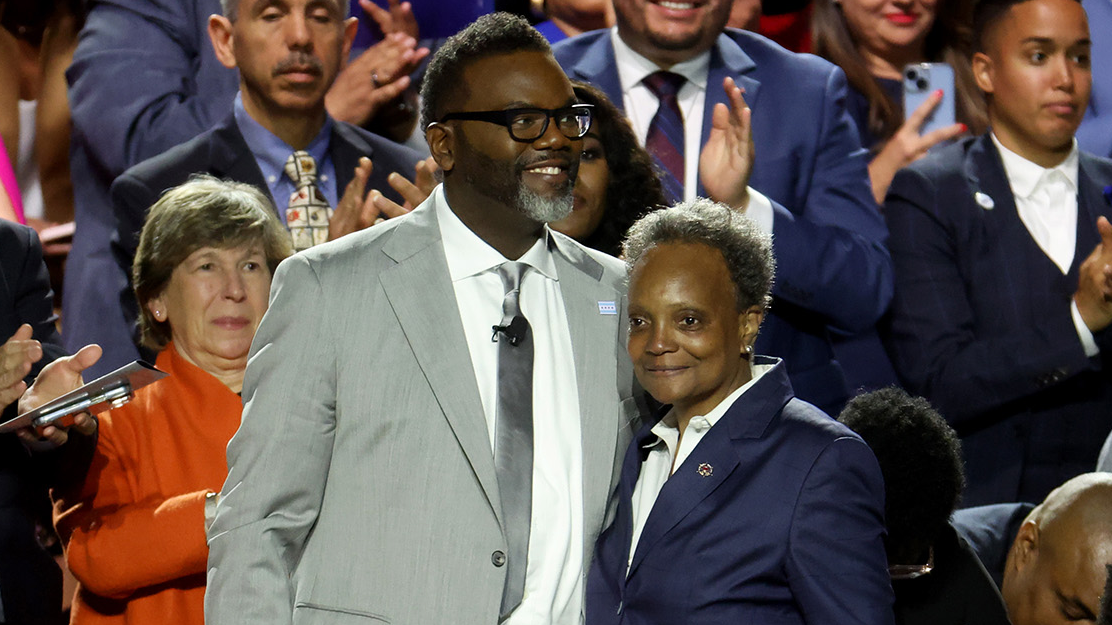 New Chicago Mayor Brandon Johnson stands with outgoing Mayor Lori Lightfoot before he is sworn in Monday at the University of Illinois at Chicago.