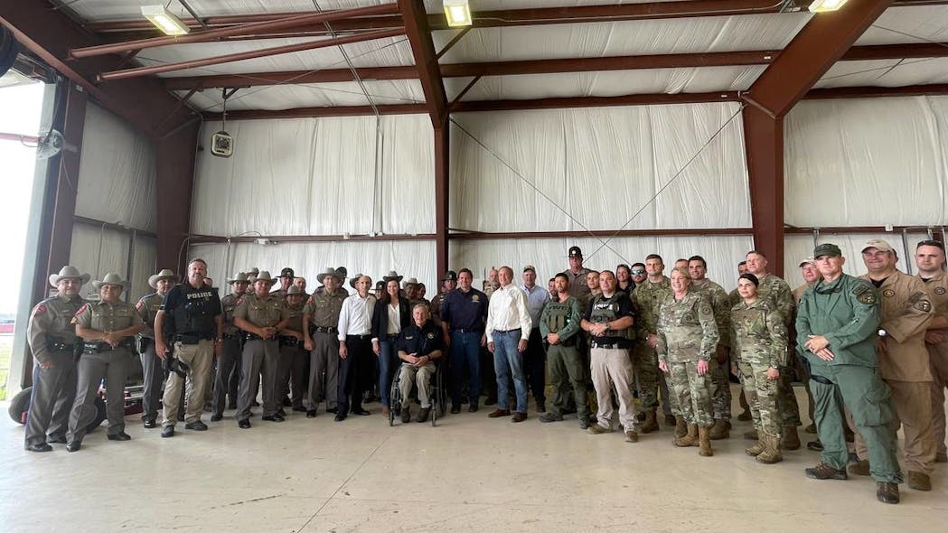 In a photo from July 17, Florida Attorney General Ashley Moody, Texas Gov. Greg Abbott and Gov. Ron DeSantis appear in an airport hangar in Del Rio, Texas.