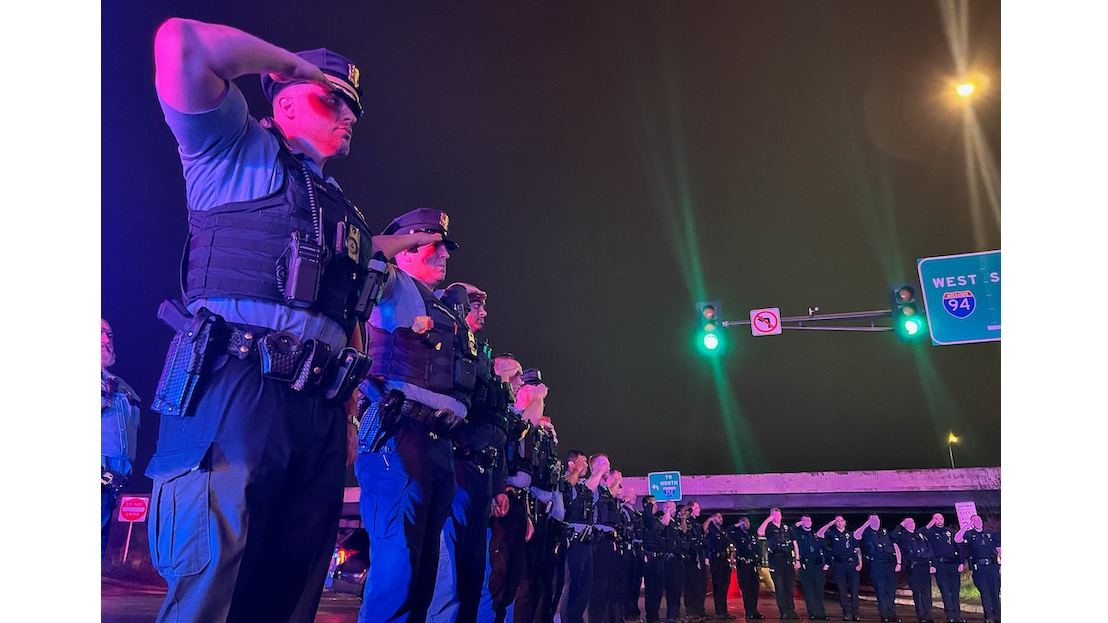 Wisconsin and Minneapolis law enforcement officers escort the body of a St. Croix County, WI, sheriff's deputy who was shot and killed while responding to a call of a drunk driver in a ditch Saturday.