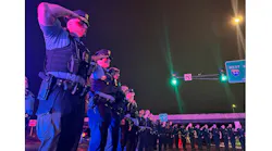 Wisconsin and Minneapolis law enforcement officers escort the body of a St. Croix County, WI, sheriff's deputy who was shot and killed while responding to a call of a drunk driver in a ditch Saturday.