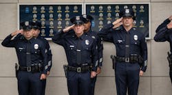 Officers salute during the National Anthem at a ceremony at LAPD Headquarters in May.