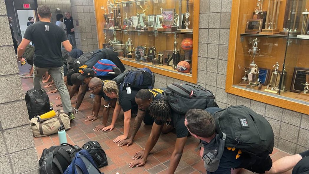 Students and New Jersey State Police troopers pair off for a bear crawl at St. Benedict&apos;s Prep School in Newark on Sep. 18.