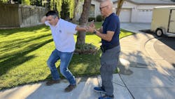 The extended wrist lock, where the hand is twisted upwards and the arm is levered down, is an effective method for keeping a little distance from the suspect. Any lock properly applied should prevent the suspect from maintaining a steady base. Notice that Lindsey is standing upright, and George is involuntarily bent down. The extended wrist lock, where the hand is twisted upwards and the arm is levered down, is an effective method for keeping a little distance from the suspect. Any lock properly applied should prevent the suspect from maintaining a steady base. Notice that Lindsey is standing upright, and George is involuntarily bent down.
