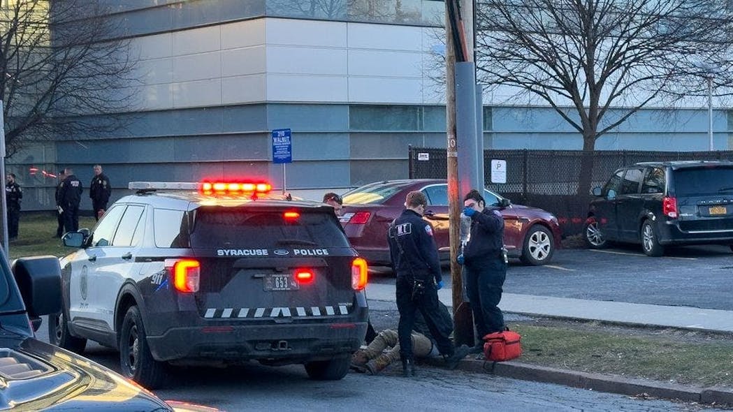 A man suspected of taking inappropriate photos of people struck two parked cars and dragged a Syracuse, NY, police officer as he tried to flee Tuesday.