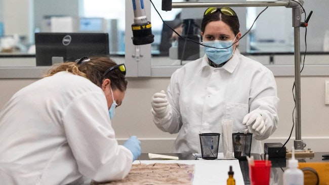 South Carolina Law Enforcement Department workers take possible evidence from a cloth at their new forensics laboratory in 2023.