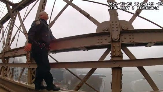 NYPD Lt. Hak Kim scales the rain-slickened Brooklyn Bridge on March 6 to rescue a woman who climbed the bridge and threatened to jump.