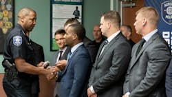 Aurora, IL, Police Chief Keith Cross (left) shakes hands with new recruits during a swearing-in ceremony in August 2023. Cross and other officials said the agency is not struggling to find recruits, despite a national shortage of police officers.
