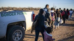 A group of migrants is processed by Border Patrol officers after crossing the U.S.- Mexico border outside Eagle Pass, Texas, in early February.
