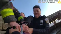 An NYPD officer is helped by fellow officers and FDNY fighters to rescue a woman who jumped into the frigid waters of the Hudson River on Thursday.