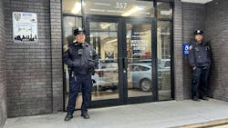NYPD officers stand outside the Midtown South stationhouse Thursday after the windows had been repaired following a vandalism incident.