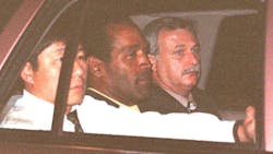 Ex-football superstar O.J. Simpson (center) is accompanied by two LAPD detectives to Parker Center after he was arrested following a 90-minute highway chase on June 17, 1994.